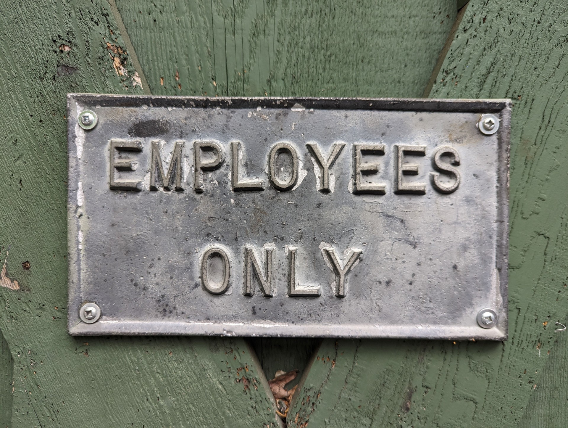 Old metal sign says 'Employees Only'